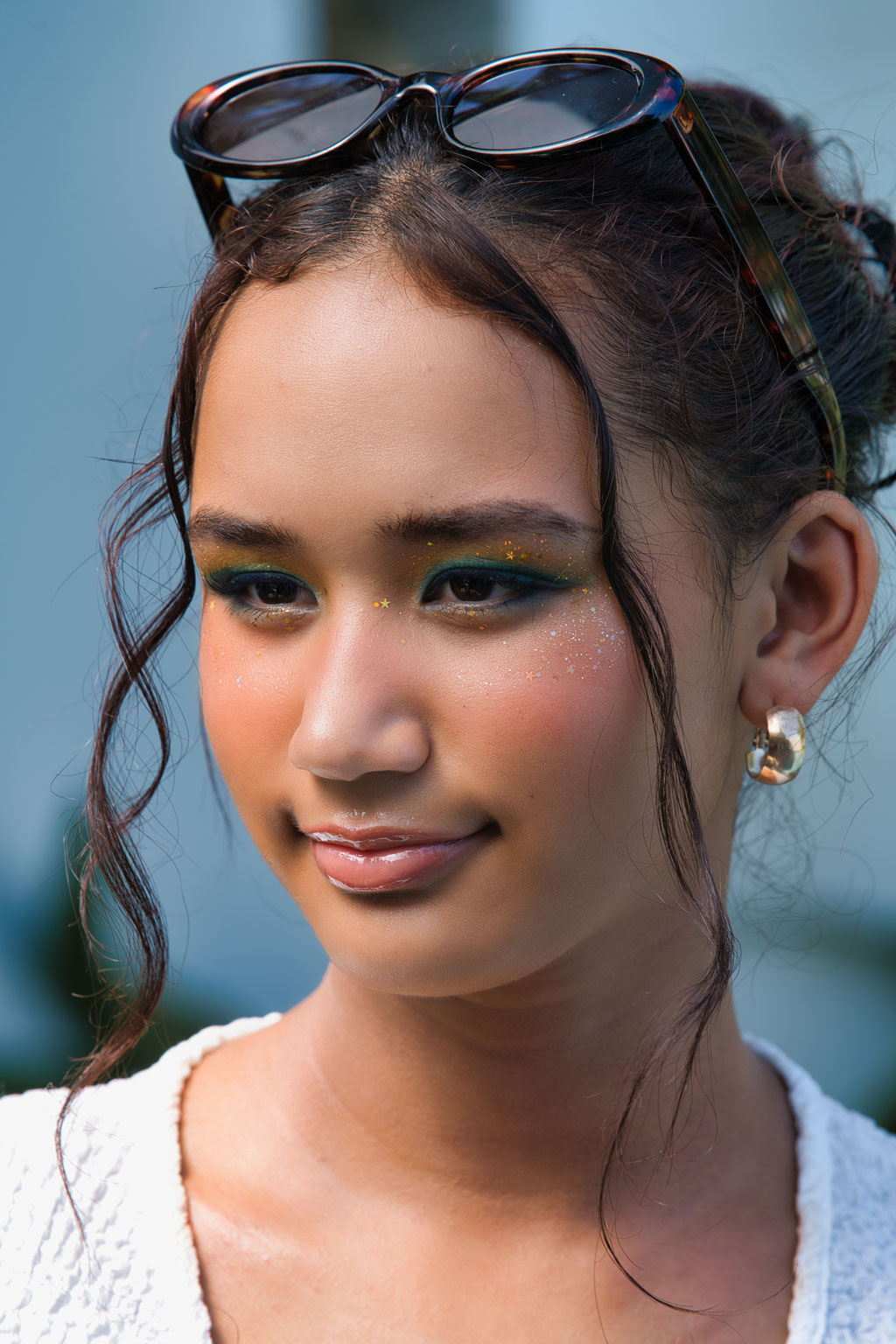 Close-up portrait of a woman with bold glitter eyeshadow. Illustrates advanced digital makeup and stylistic effects using new AI Photoshop features.