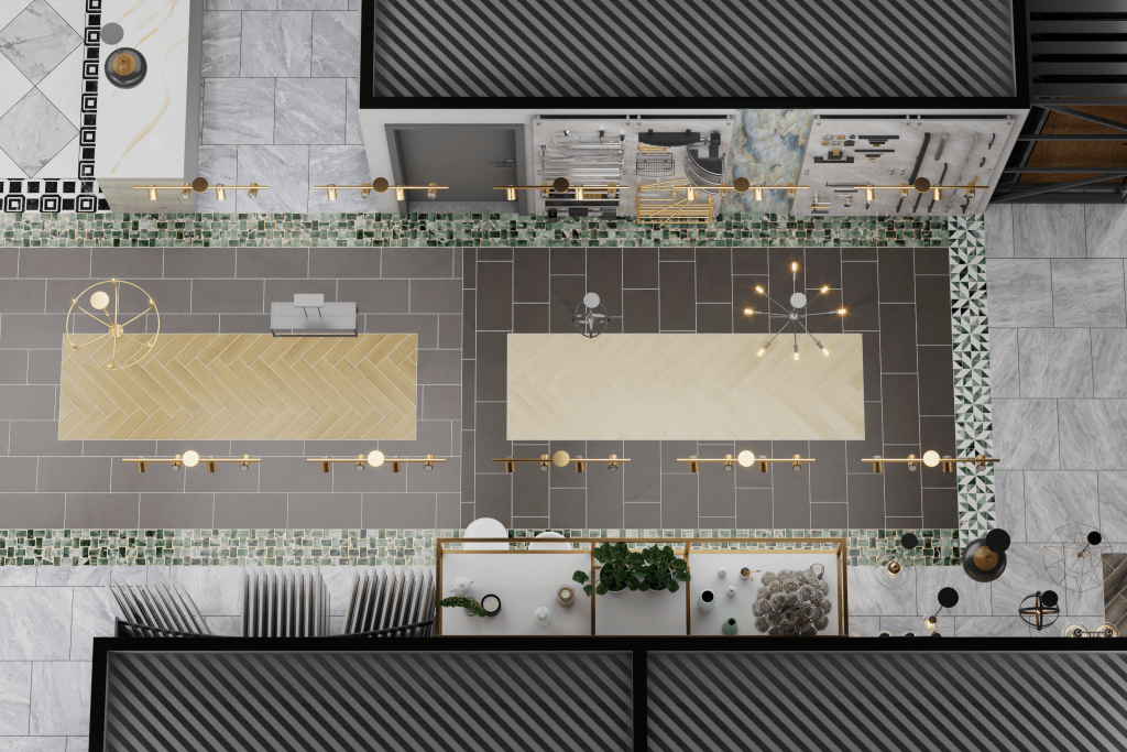 Top-down 3D render of a showroom section, featuring display islands with light wood herringbone tops, grey floor tiles, and decorative green mosaic borders, illuminated by modern chandeliers.