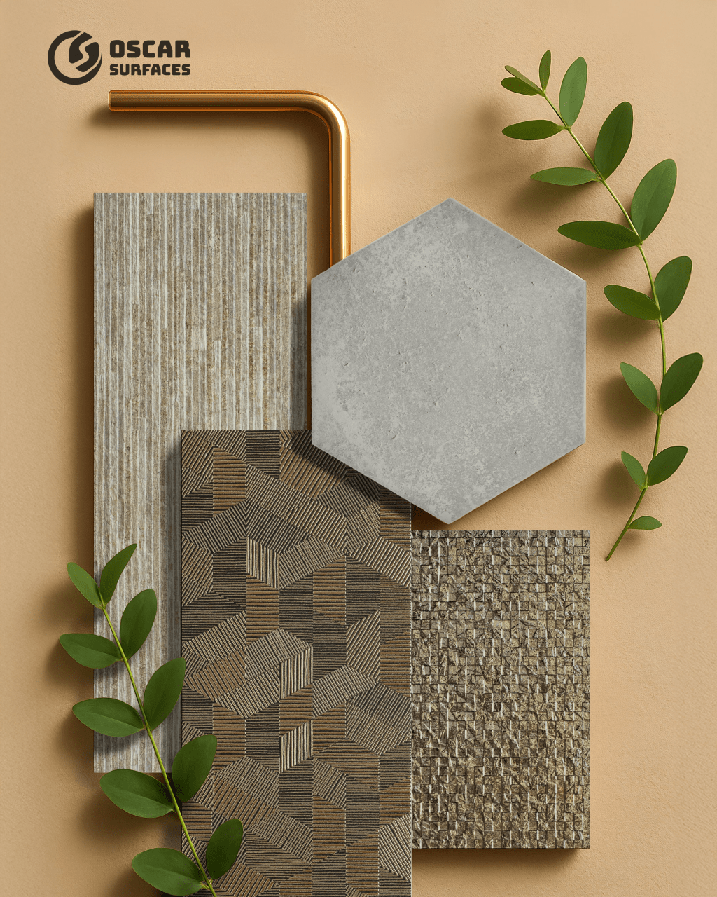 A flat lay of textured tiles from Oscar Surfaces in neutral and brown tones, including a grey hexagon, arranged with a copper pipe and green leaves on a tan background.