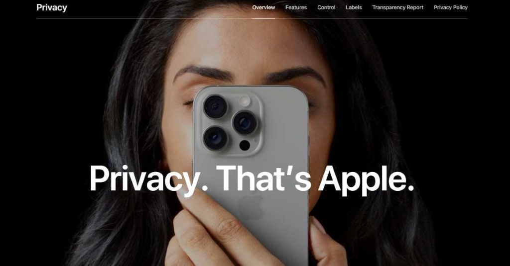 Close-up of a person holding a smartphone over their face with the text "Privacy. That's Apple." on a screen.